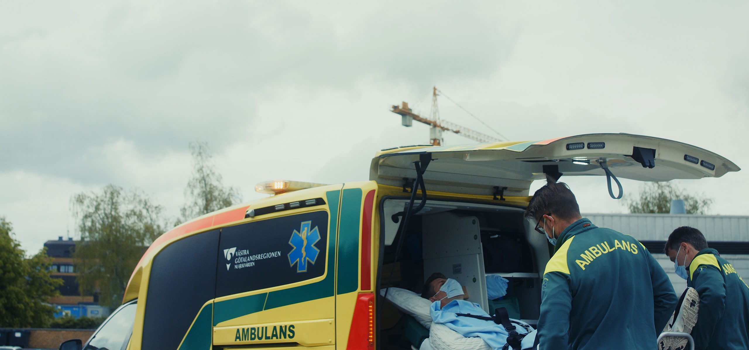 Hero Image Ambulance Workers are Wheeling a Patient on a Stretcher into the Back of an Ambulance
