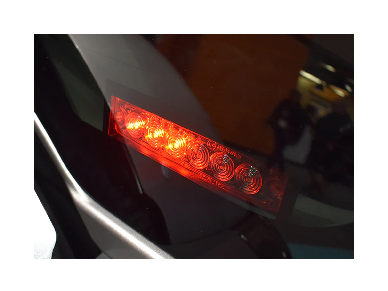 Zephyr LED Module Shield In Situ Close Up Vehicle Window with Red 6-Way Zephyr LED Module Lit